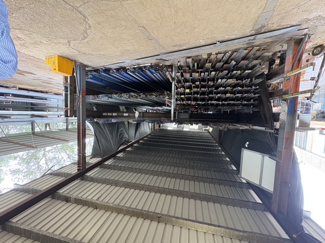 Long-length rack loaded with structural sections, purlins and pipe under cover