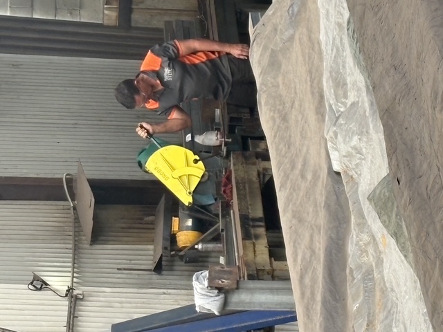 Worker at the cold-cut saw in the Marshall Steel workshop